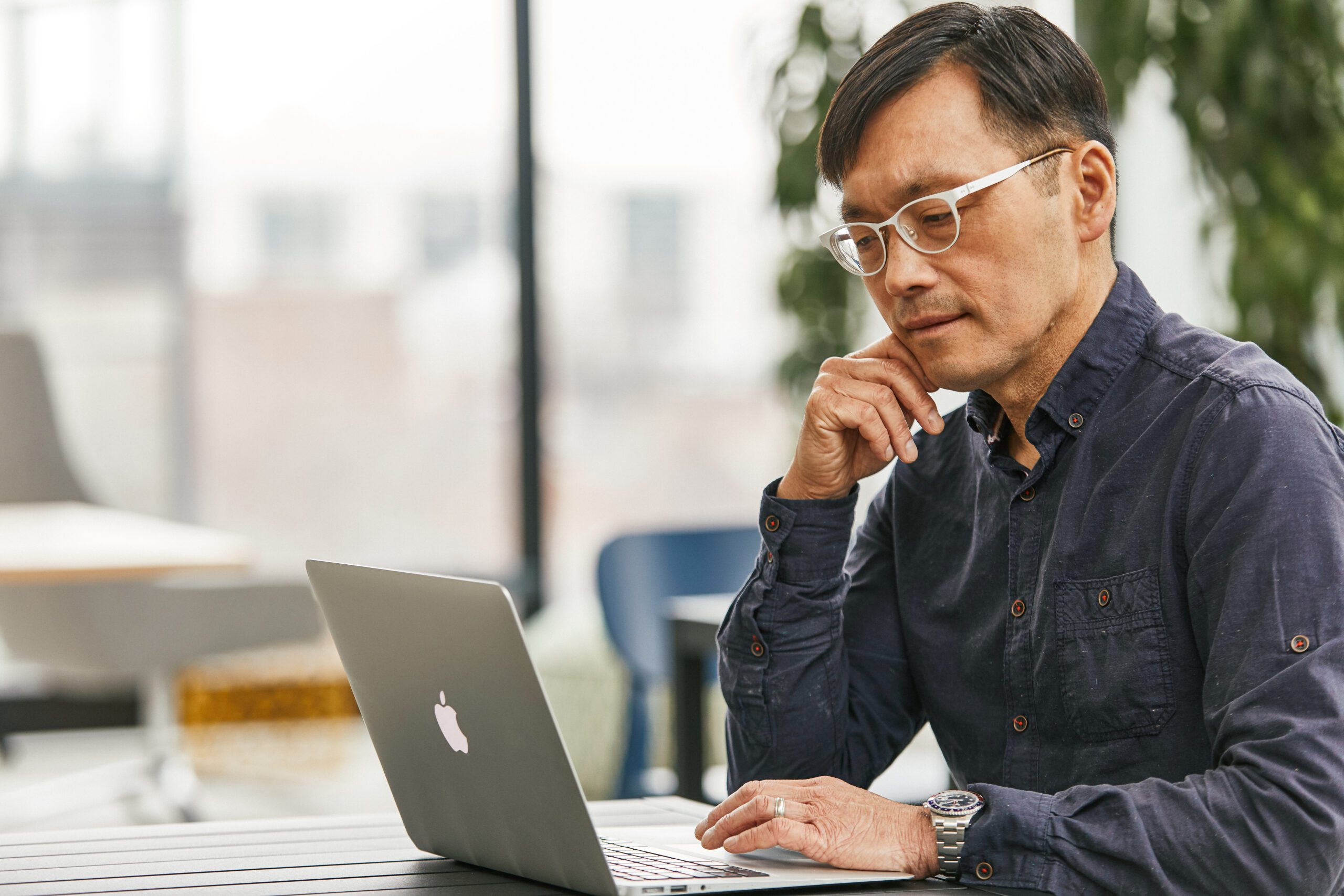 older man sits at a computer researching affordability of retirement.
