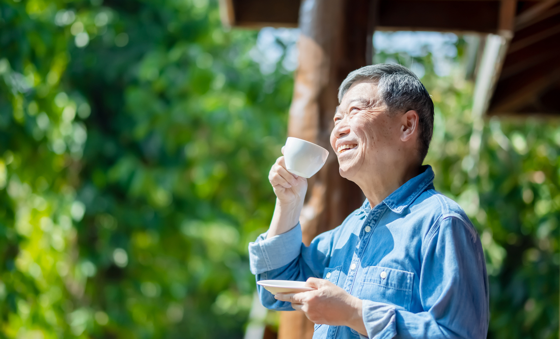 Un retraité savoure un café et sourit lors de son premier voyage à la retraite