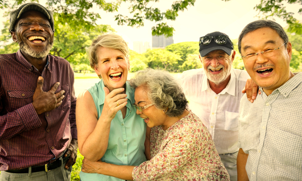 Smiling group of engaged seniors having fun at the park.
