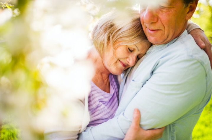 A happy couple embracing outside on a sunny fall day.