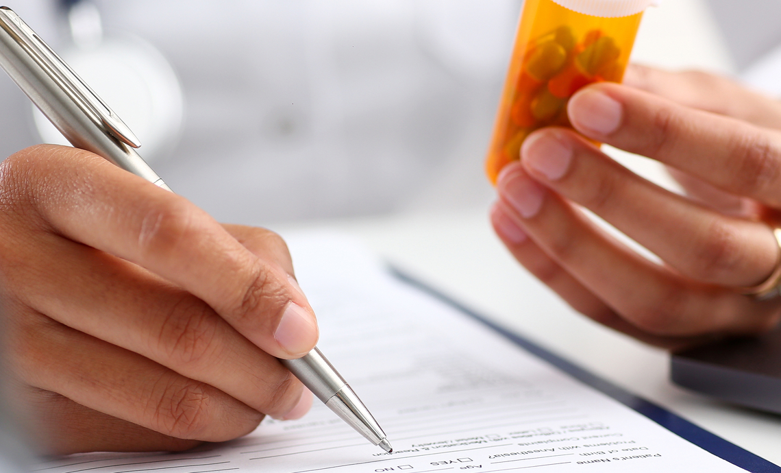 close up of hands filling a prescription