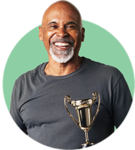 Smiling retiree in a workout top holding a trophy