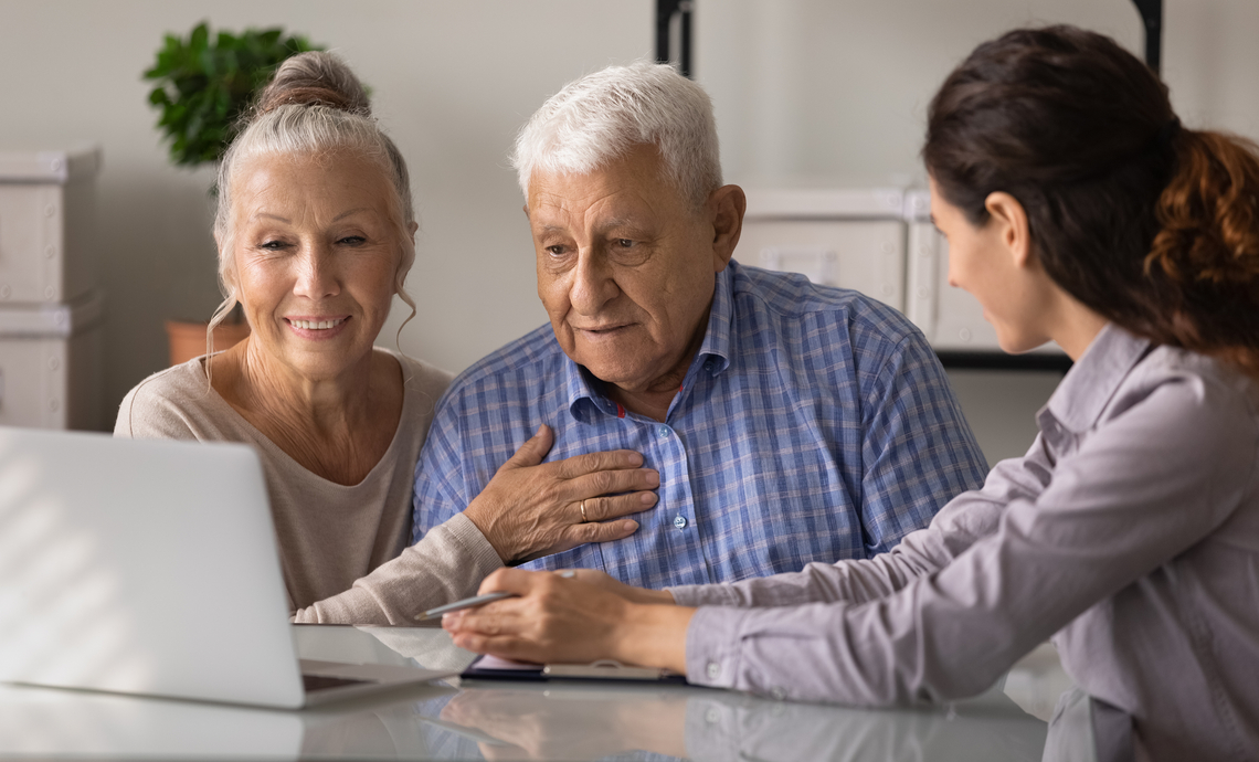 Married couple sitting at a table with a financial advisor discussing their philanthropy goals.