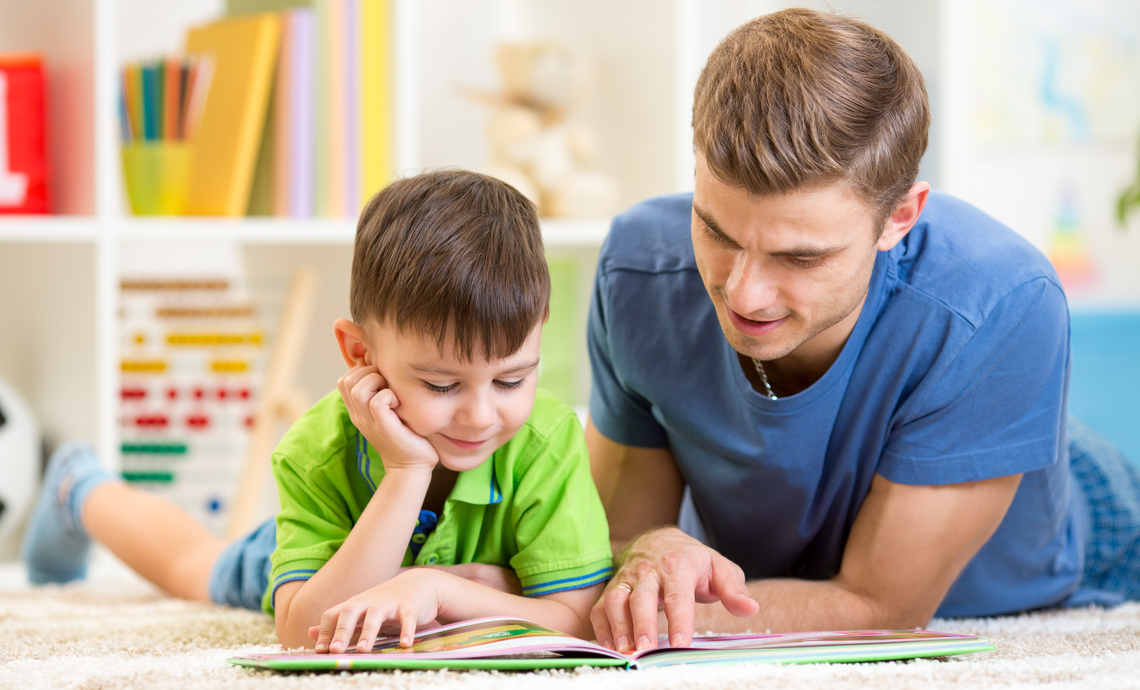Father and son reading together and discussing the book