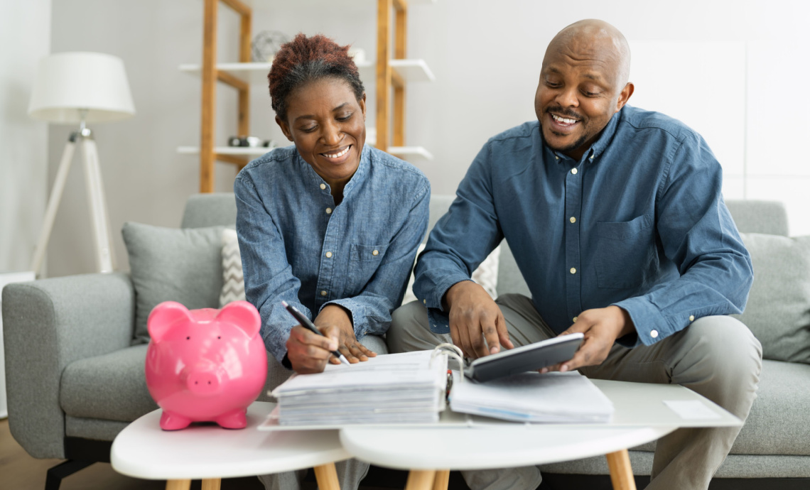 Un couple, assis sur un divan, passe en revue son plan financier
