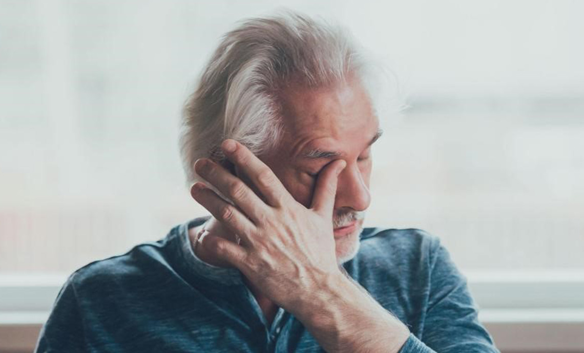 Homme âgé se frottant les yeux