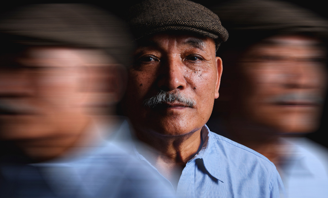 Older man with hat on in centre. Two blurry images of same man on either side.