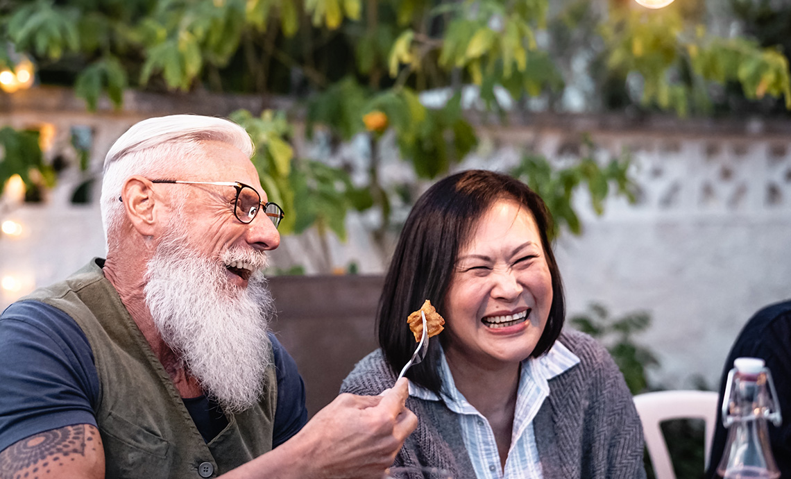 amis plus âgés prenant un repas ensemble à l'extérieur