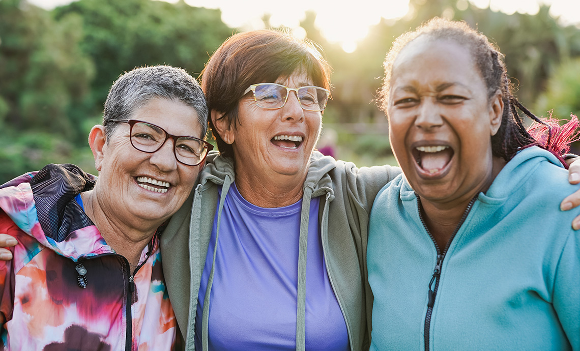 Three smiling older adults outside